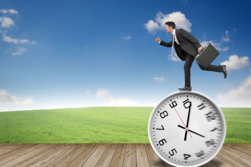 Businessman running on a large clock, symbolizing life time