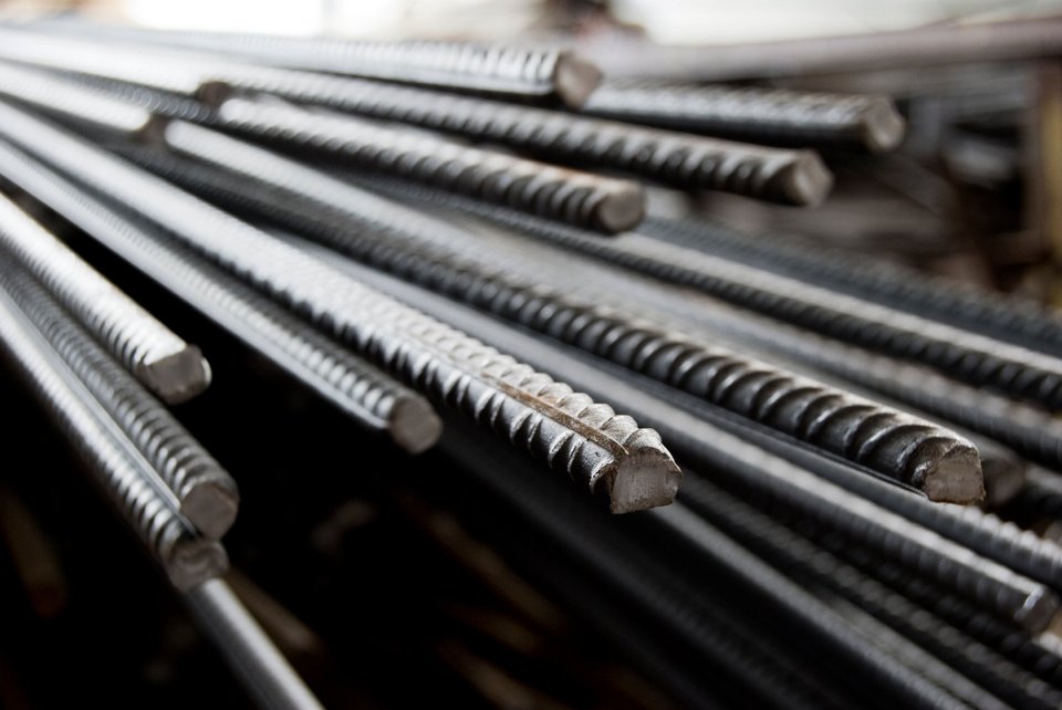 Stapel metalen wapeningsstaven met ribbels, liggend en geordend.