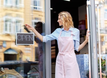 Een vrouw die haar winkel opent