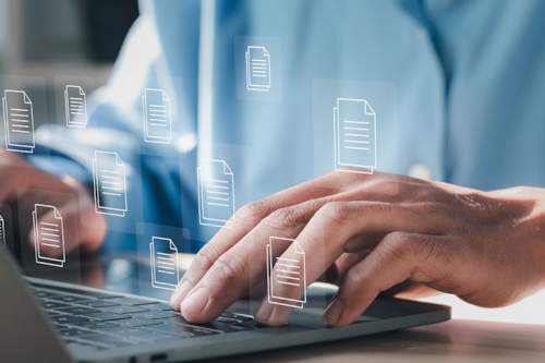 Digitalt arbete på en bärbar dator, händer som skriver på tangentbordet och symboler för dokument visas över bilden.