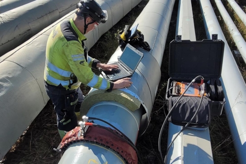 En man använder Long Range Screening, även känt som LRUT, för upphöjda och synliga rör. Provningen är en icke-förstörande metod för att snabbt hitta korrosionsskador i olika slags rörledningar utan att ta rören ur drift..