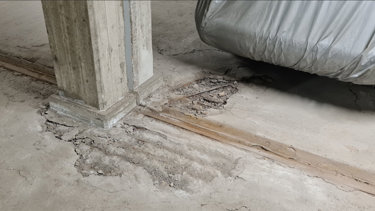 Korrosion i betonggolvet har lett till stora skador i garaget, alldeles bredvid en pelare..
