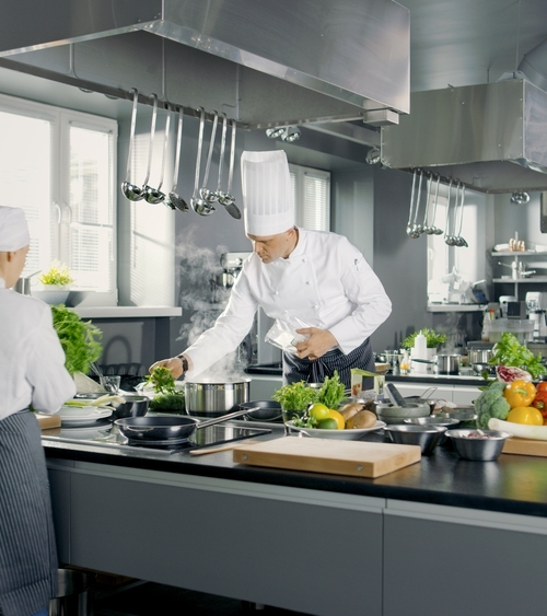 Chefs in a restaurant kitchen which can be auditing by Kiwa